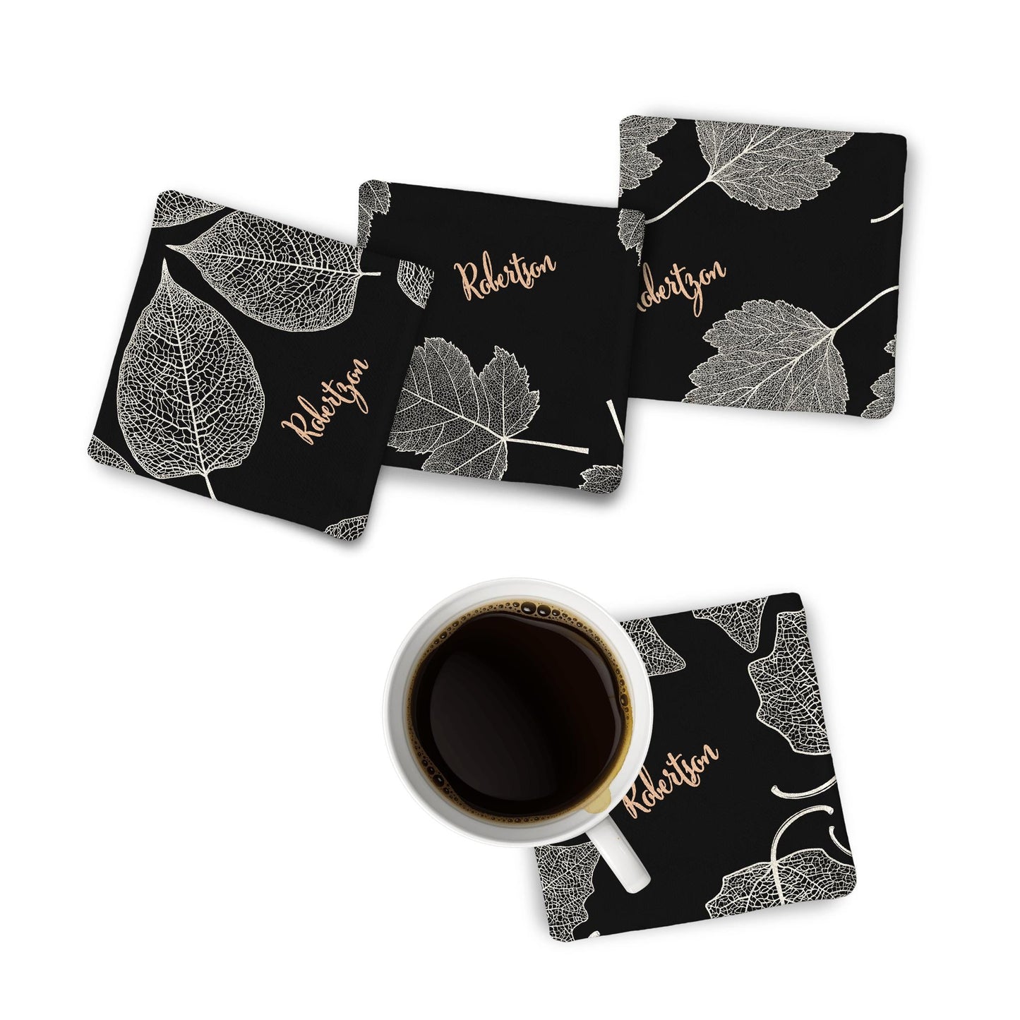 4 Fabric Coasters with Autumn Leaves print with a black-coffee mug on a white surface