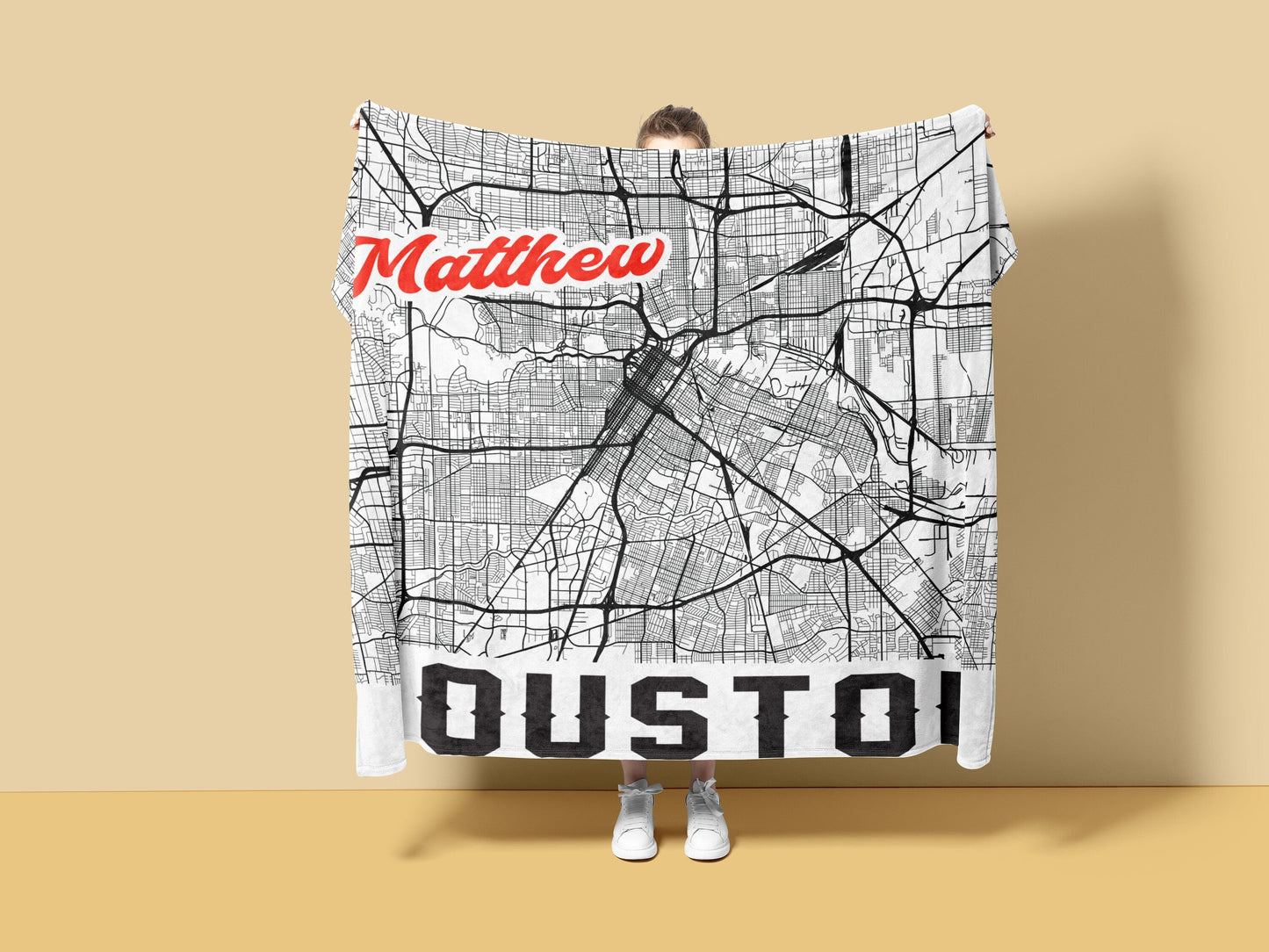 Person holding a white blanket in a yellow background with personalized city map of houston and customized name