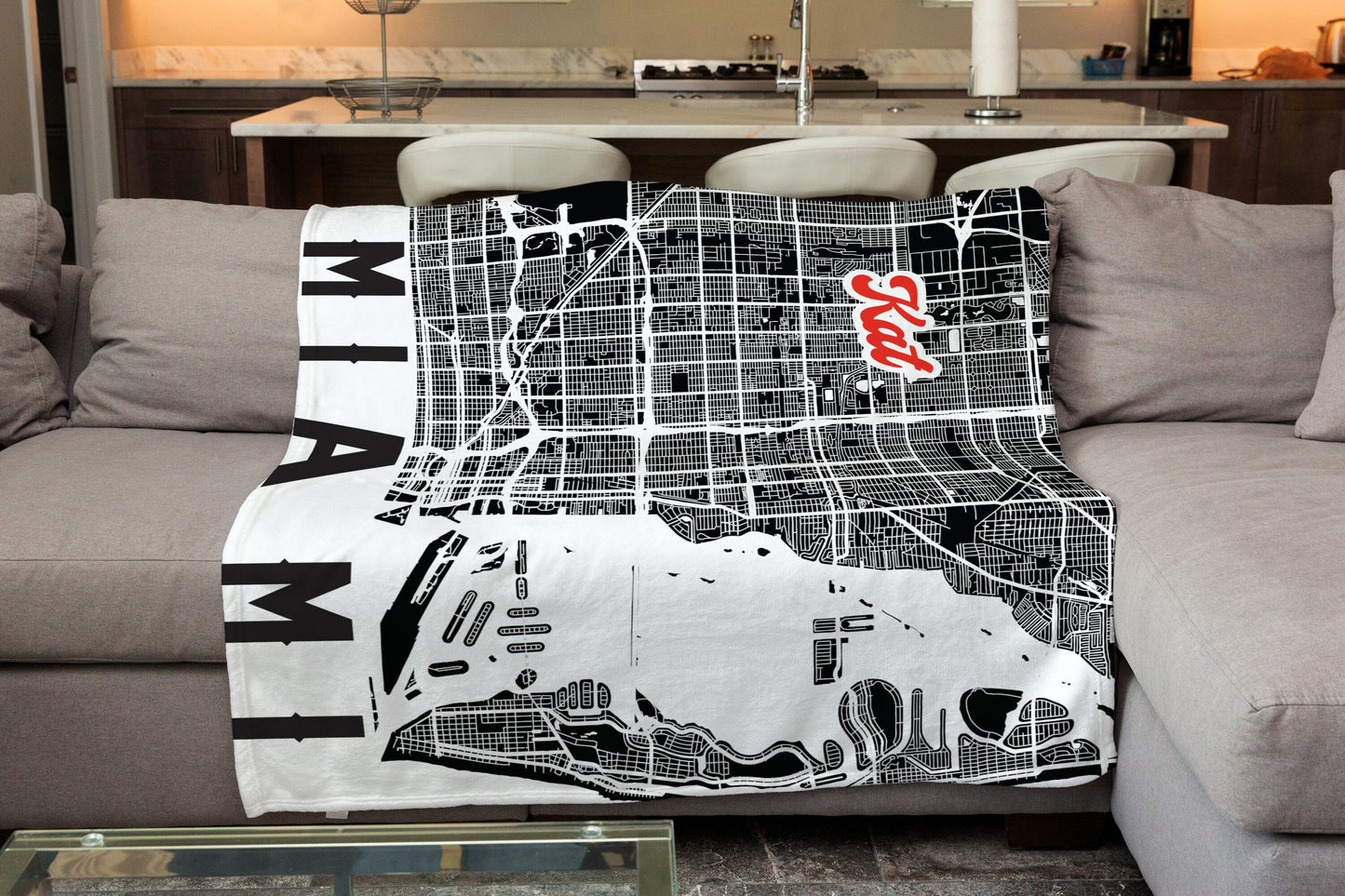 A white blanket spreaded on sofa with Miami city map print and customized name, with a living room background