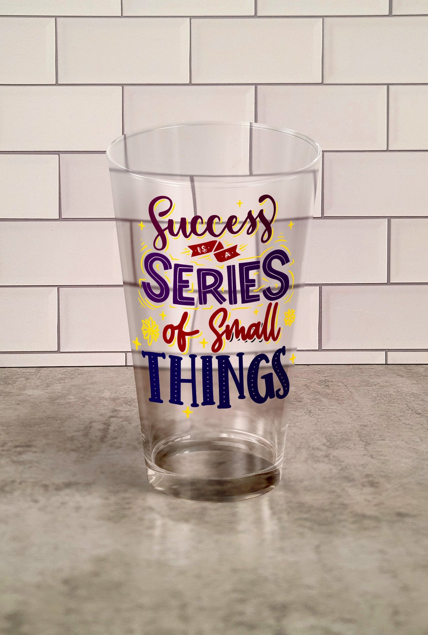 Success Is A Series Of Small Things transparent Tumbler Glass against a slipslap wall