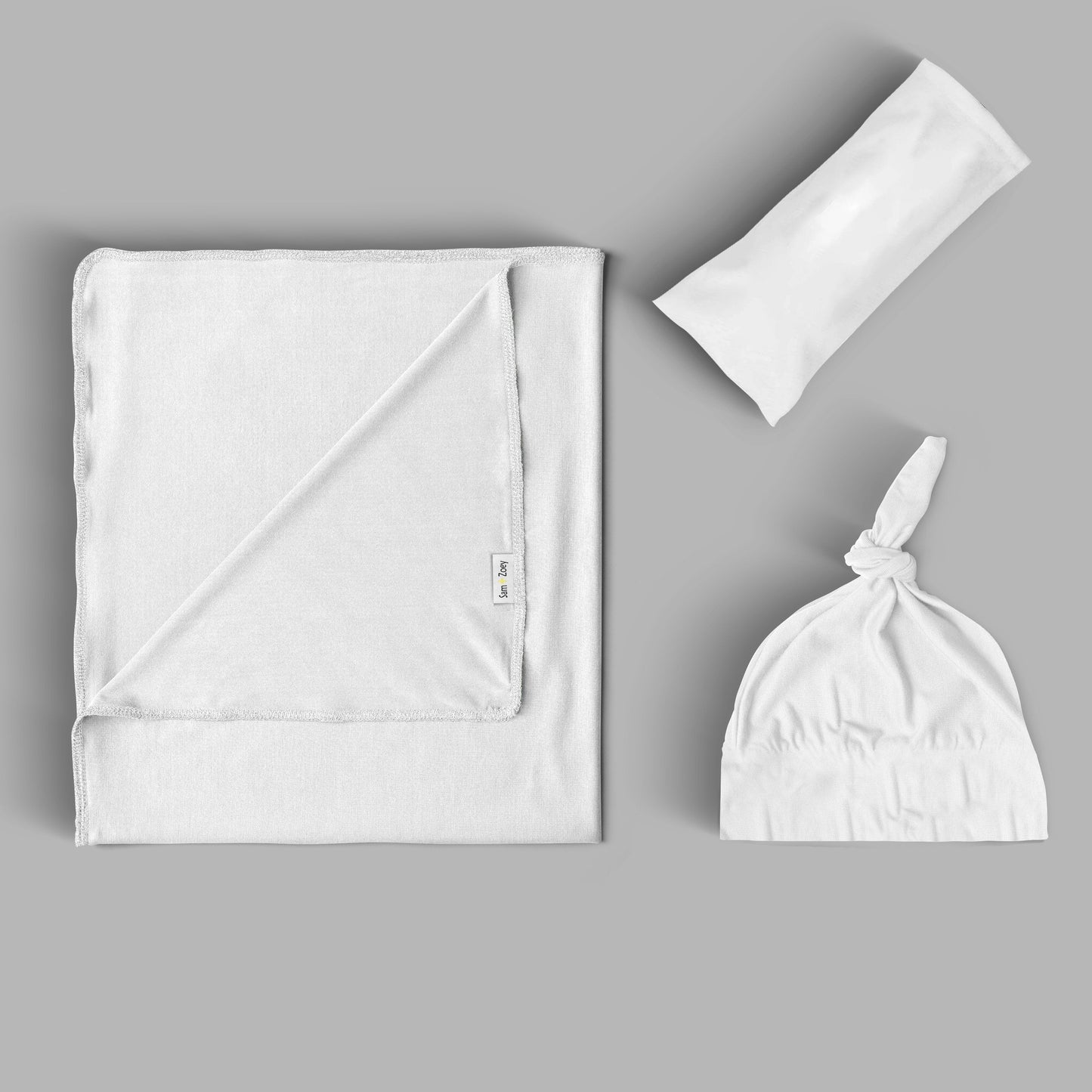 An Edge to Edge Personalized Swaddle set displayed on grey surface