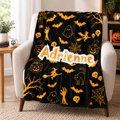 Custom name on vibrant pumpkin Halloween fleece throw blanket as personalized spooky gift

