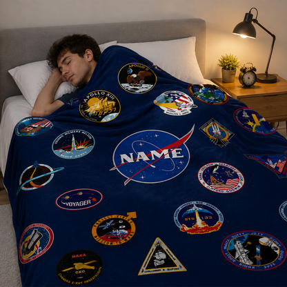 Person wrapped in personalized space mission patch throw blanket as birthday gift
