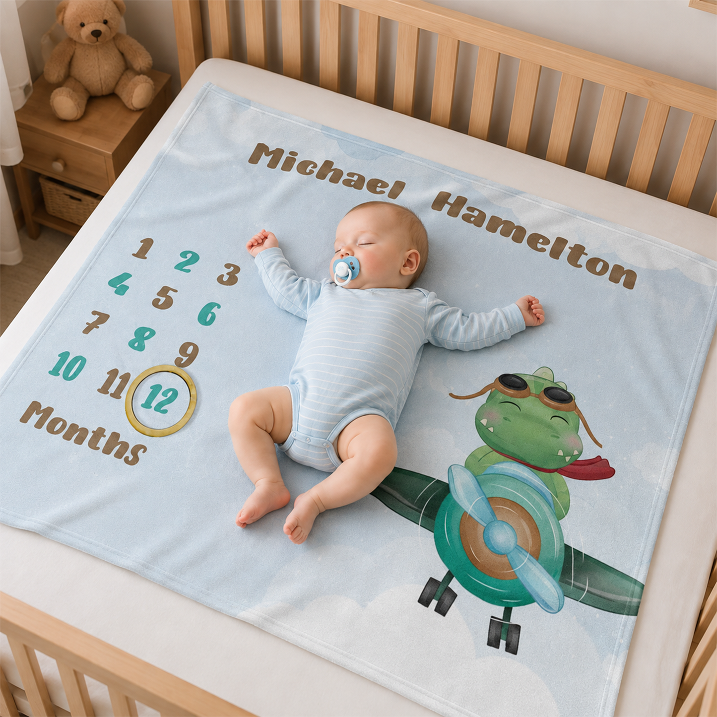 Baby wrapped in personalized dinosaur milestone blanket as thoughtful baby shower gift
