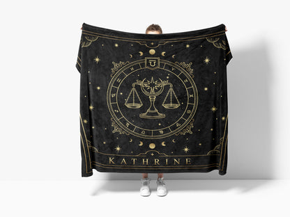 Peron holding a black throw sherpa blanket with libra Zodiac sign and customized name with a white background